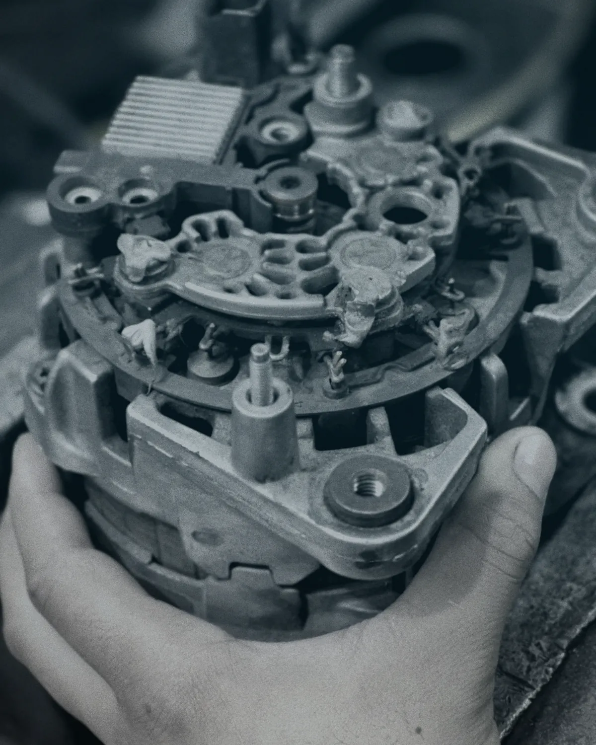 Técnico de ElectroCar sosteniendo un alternador desarmado durante su reparación